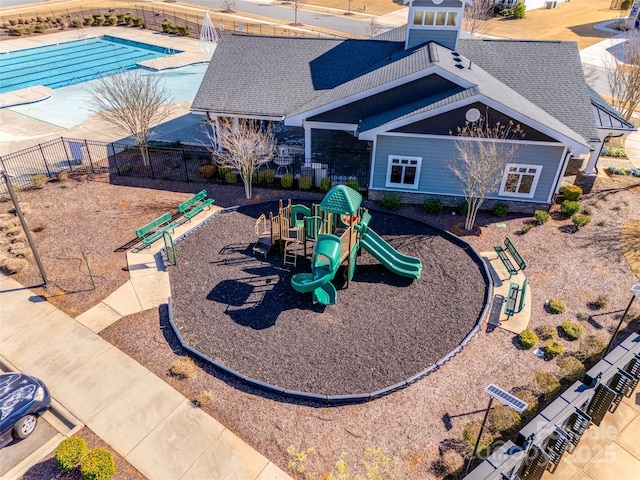 community play area featuring a community pool and fence