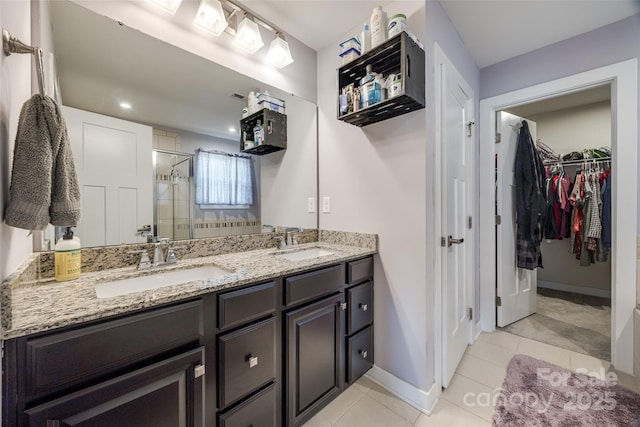 full bathroom featuring double vanity, tile patterned floors, a sink, and a shower stall