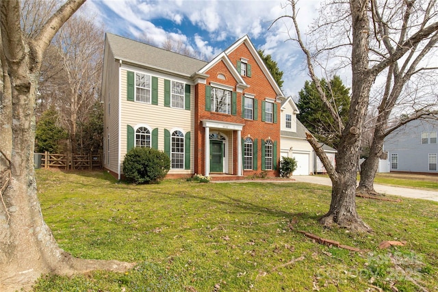 view of front of property with a garage, brick siding, concrete driveway, fence, and a front yard