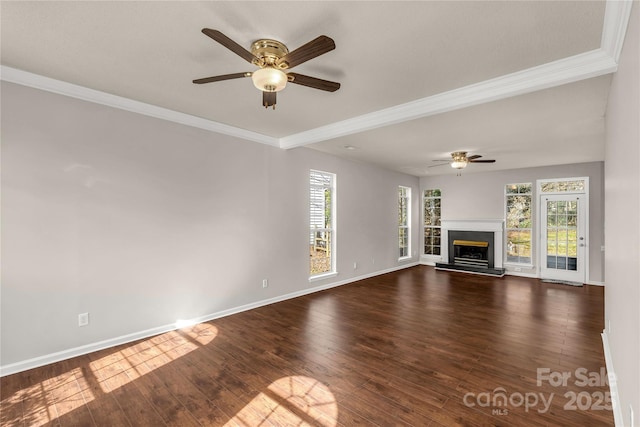 unfurnished living room with ornamental molding, a fireplace with raised hearth, dark wood-type flooring, and baseboards