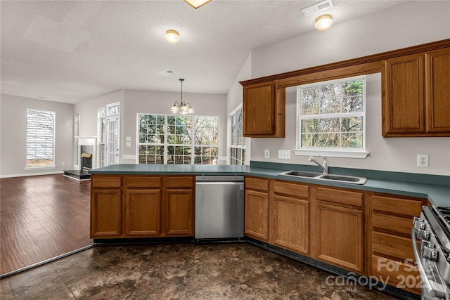 kitchen with stainless steel appliances, brown cabinetry, visible vents, and a sink