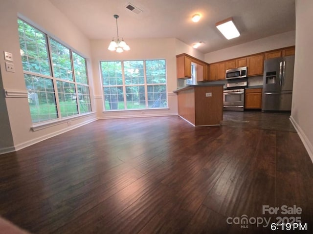 9138 Babbitt Way, Charlotte, NC 28216 - kitchen with stainless steel appliances, a chandelier, dark wood-style floors, brown cabinets, and a peninsula