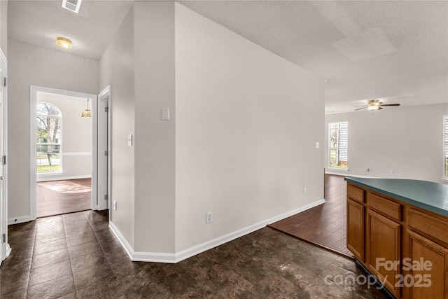 9138 Babbitt Way, Charlotte, NC 28216 - kitchen featuring brown cabinets, a textured ceiling, a ceiling fan, and dark countertops