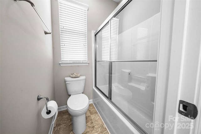 full bathroom with combined bath / shower with glass door, baseboards, and toilet