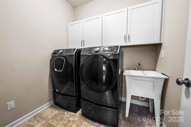 washroom featuring cabinet space, independent washer and dryer, and baseboards