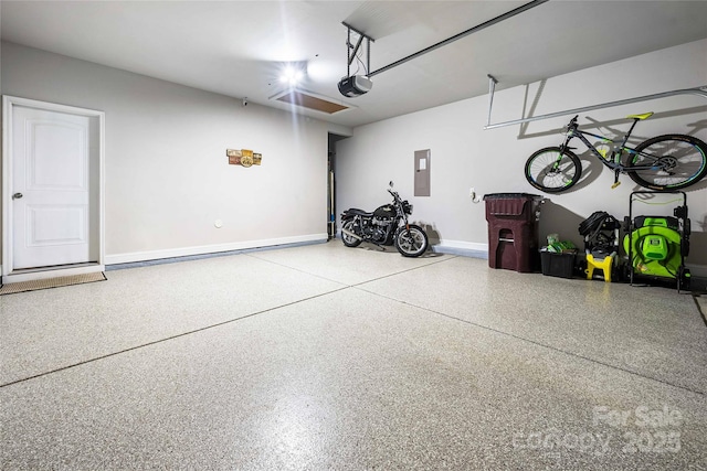 garage with electric panel, a garage door opener, and baseboards