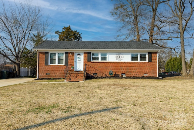 view of front facade with brick siding, crawl space, a front yard, and fence