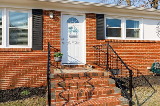 view of exterior entry featuring brick siding