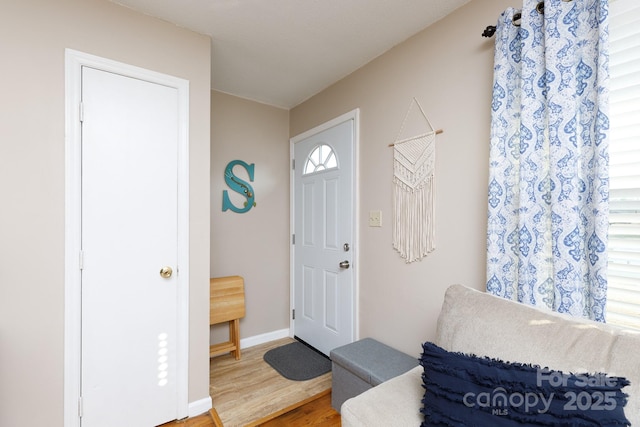 foyer featuring baseboards and wood finished floors