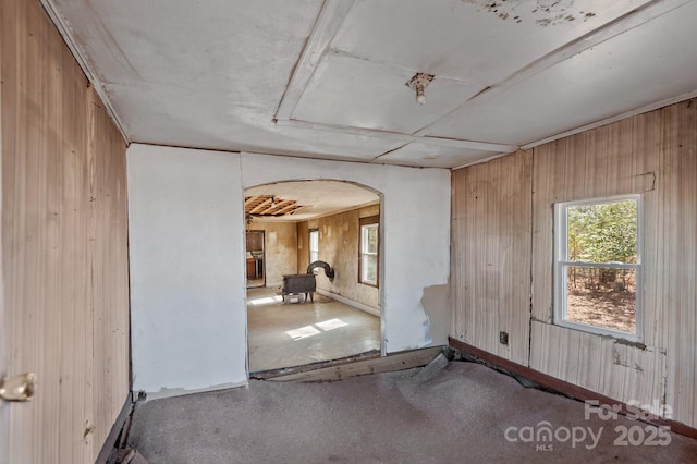 empty room with arched walkways and wood walls