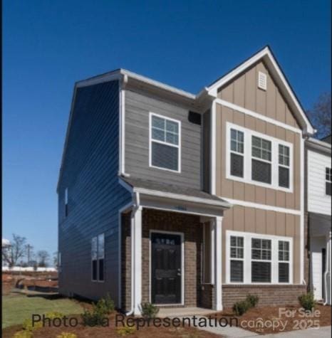 view of front facade with board and batten siding and brick siding