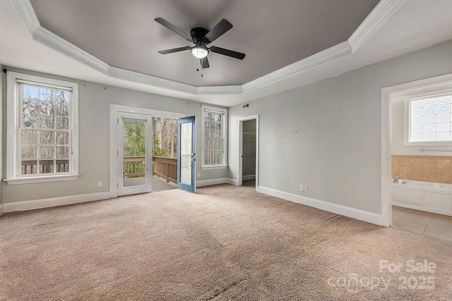 unfurnished bedroom featuring ornamental molding, a tray ceiling, access to outside, and light carpet