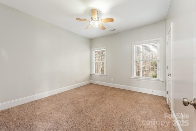 empty room with light carpet, ceiling fan, visible vents, and baseboards