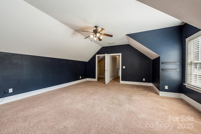 bonus room featuring ceiling fan, lofted ceiling, light colored carpet, visible vents, and baseboards