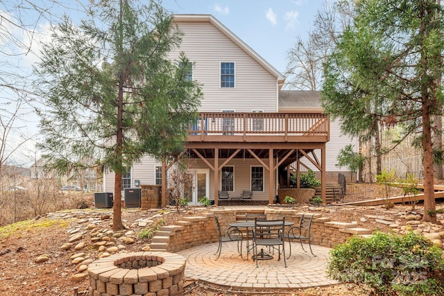 rear view of house with a fire pit, stairs, a wooden deck, a patio area, and central AC