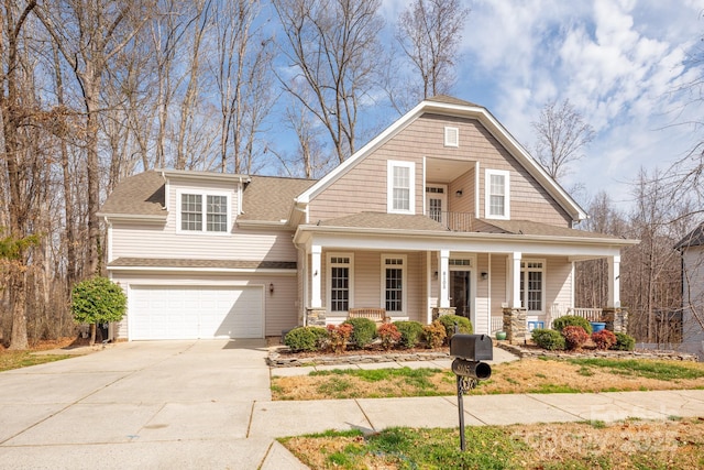 view of front of home featuring a porch, concrete driveway, roof with shingles, and an attached garage