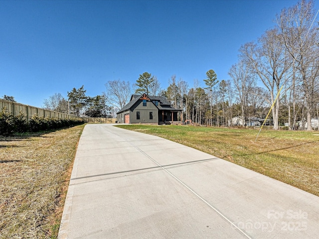 view of front of house featuring fence and a front lawn