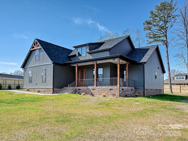 modern farmhouse style home featuring roof with shingles, a porch, a front lawn, and crawl space