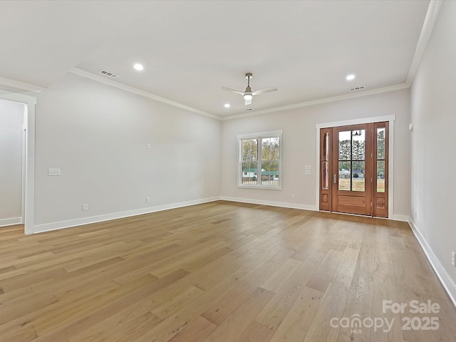 unfurnished living room with light wood-style floors, visible vents, baseboards, and crown molding