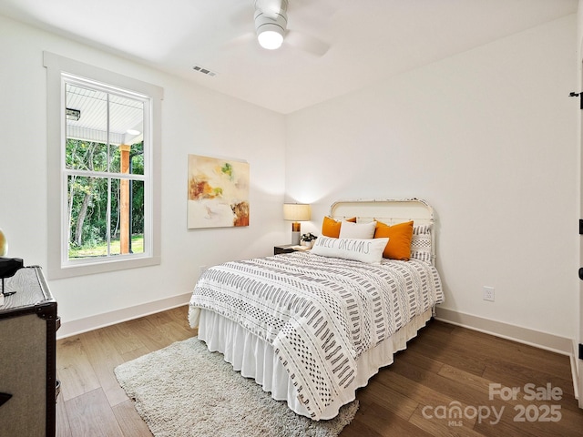 bedroom featuring ceiling fan, wood finished floors, visible vents, and baseboards