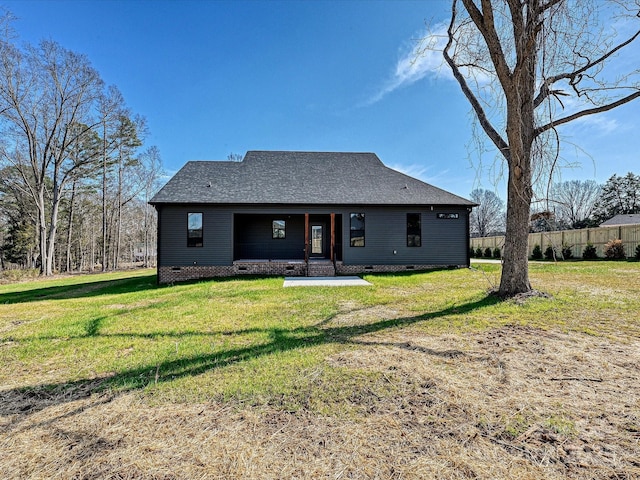 back of property with crawl space, a shingled roof, a porch, and a lawn