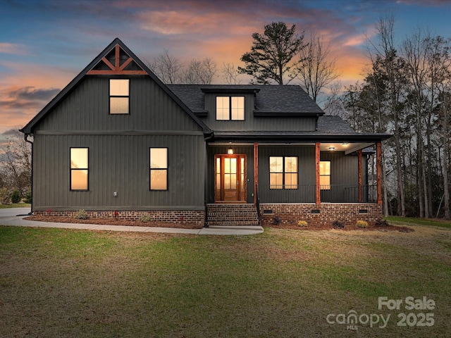 modern farmhouse style home featuring roof with shingles, crawl space, a porch, board and batten siding, and a front yard