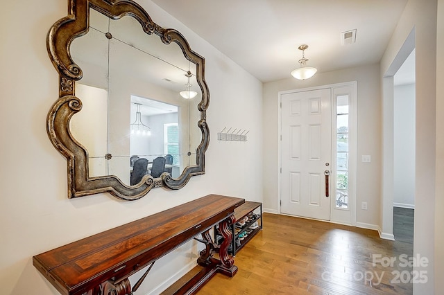 entrance foyer featuring visible vents, baseboards, and wood finished floors