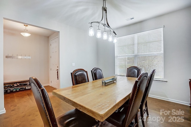 dining room featuring visible vents, baseboards, and wood finished floors