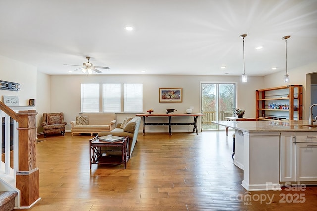 living area featuring recessed lighting, light wood-type flooring, and stairs