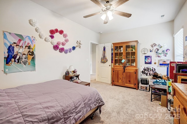 bedroom with light colored carpet and a ceiling fan