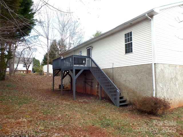 back of property featuring a deck and stairway