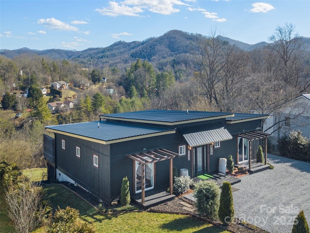 back of house with metal roof and a mountain view