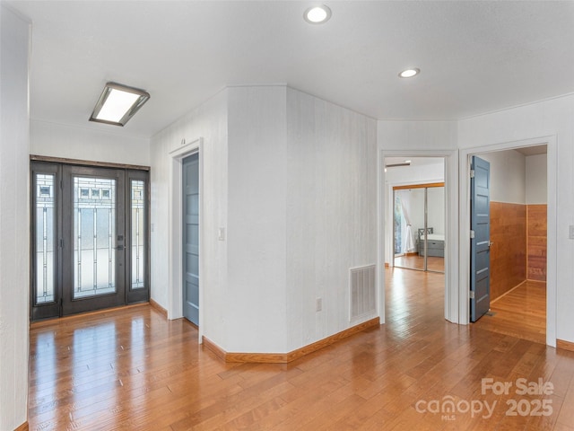 foyer entrance featuring visible vents, baseboards, hardwood / wood-style flooring, and recessed lighting