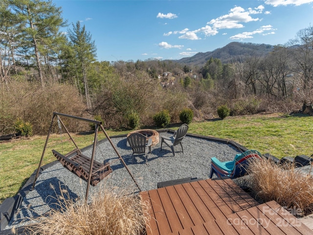 exterior space featuring an outdoor fire pit, a mountain view, and a wooded view