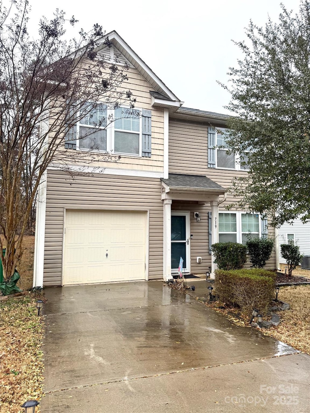 traditional-style house featuring concrete driveway and an attached garage