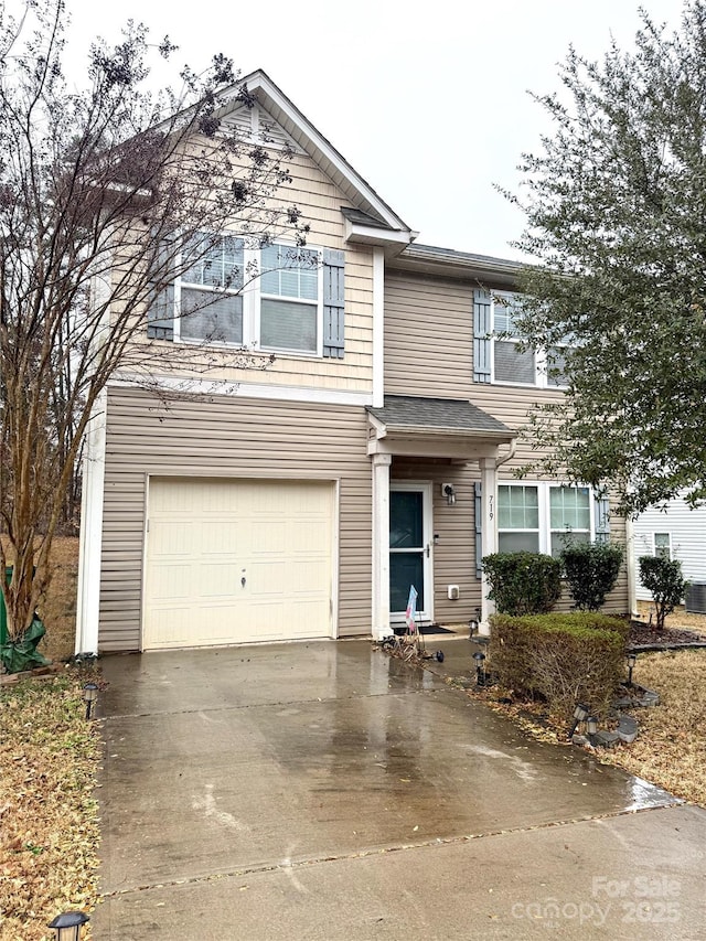 traditional-style house featuring concrete driveway and an attached garage