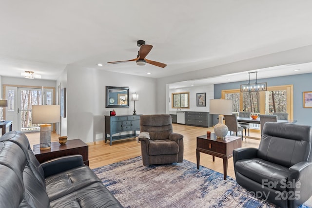 living area featuring ceiling fan with notable chandelier, light wood finished floors, and recessed lighting