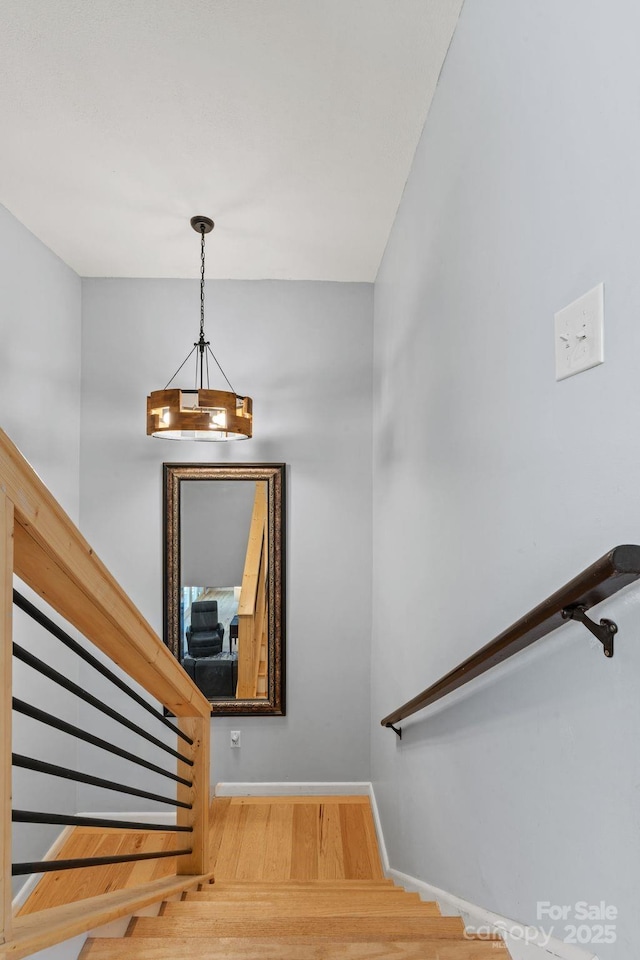 stairway with baseboards and wood finished floors