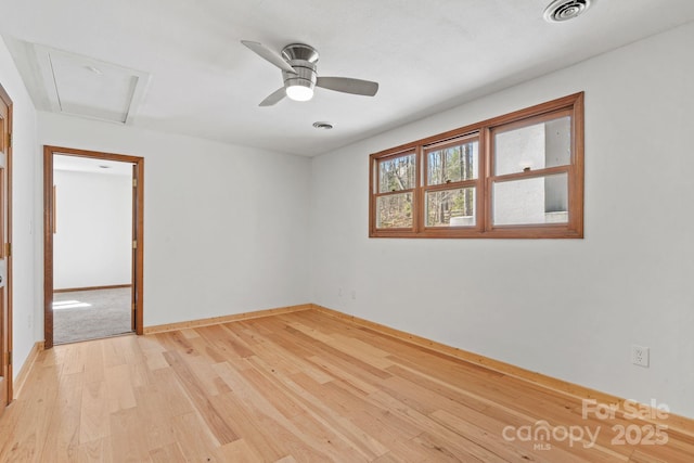 unfurnished room with light wood-style floors, baseboards, visible vents, and ceiling fan