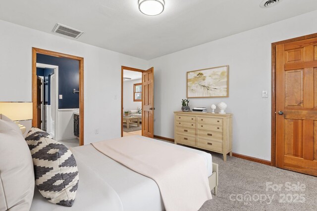 bedroom featuring light carpet, ensuite bath, baseboards, and visible vents