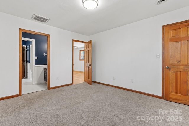 unfurnished bedroom with carpet, visible vents, and baseboards