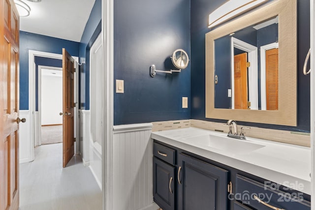 bathroom with a wainscoted wall and vanity