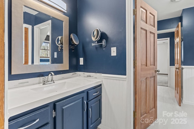 bathroom with a wainscoted wall and vanity