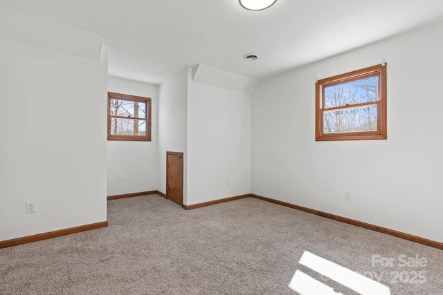 empty room featuring baseboards, visible vents, and carpet flooring