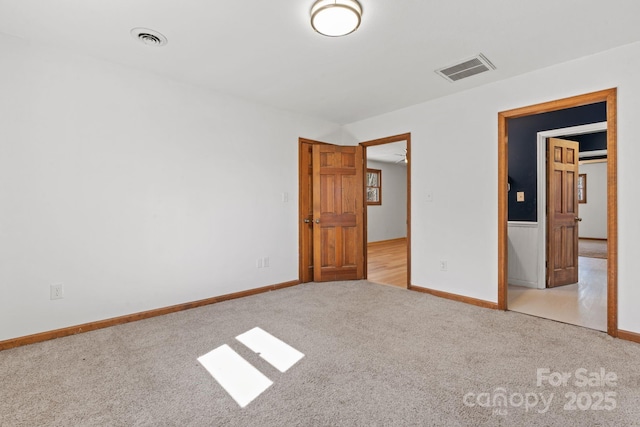 unfurnished bedroom featuring carpet flooring, visible vents, and baseboards