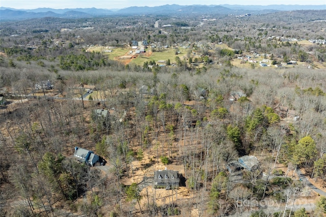 drone / aerial view with a mountain view and a view of trees