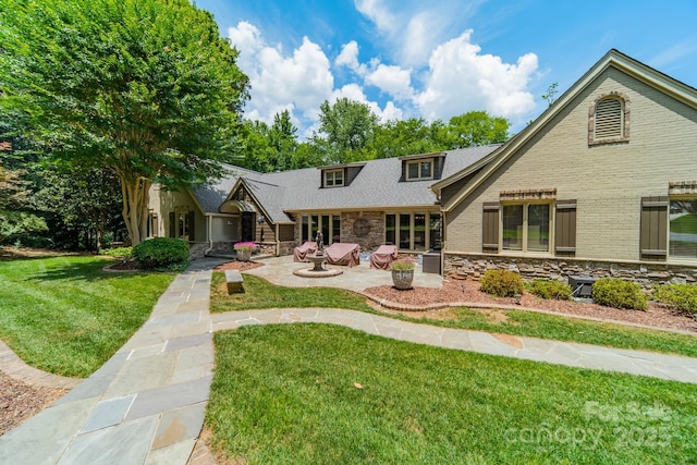 exterior space with stone siding, brick siding, a lawn, and a patio area