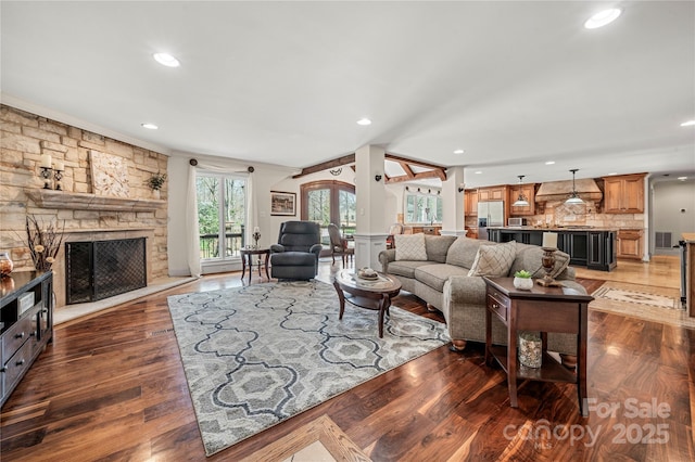 living room with recessed lighting, visible vents, a fireplace, and wood finished floors