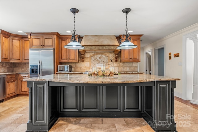 kitchen featuring stainless steel appliances, premium range hood, brown cabinetry, and light stone countertops