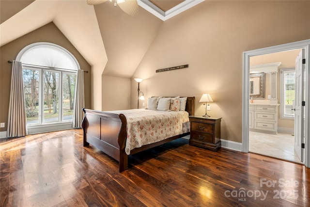 bedroom with connected bathroom, vaulted ceiling, and wood finished floors